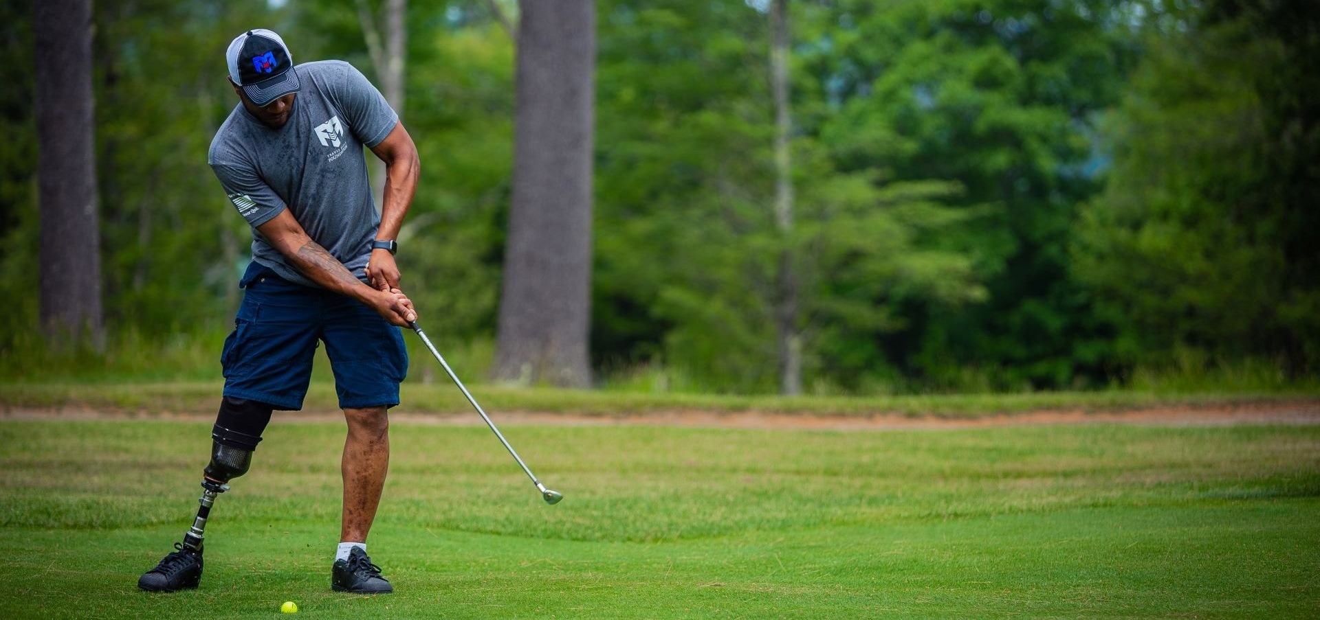 Man golfing in Travis Mills branded apparel
